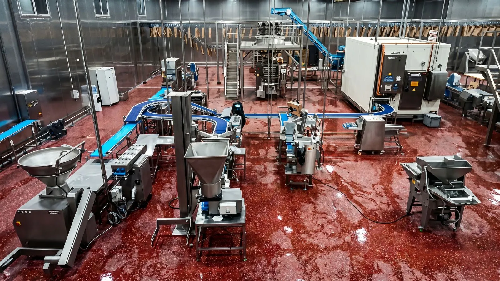 Blick von oben in eine Lebensmittelproduktion mit Förderbändern und Verpackungsanlage